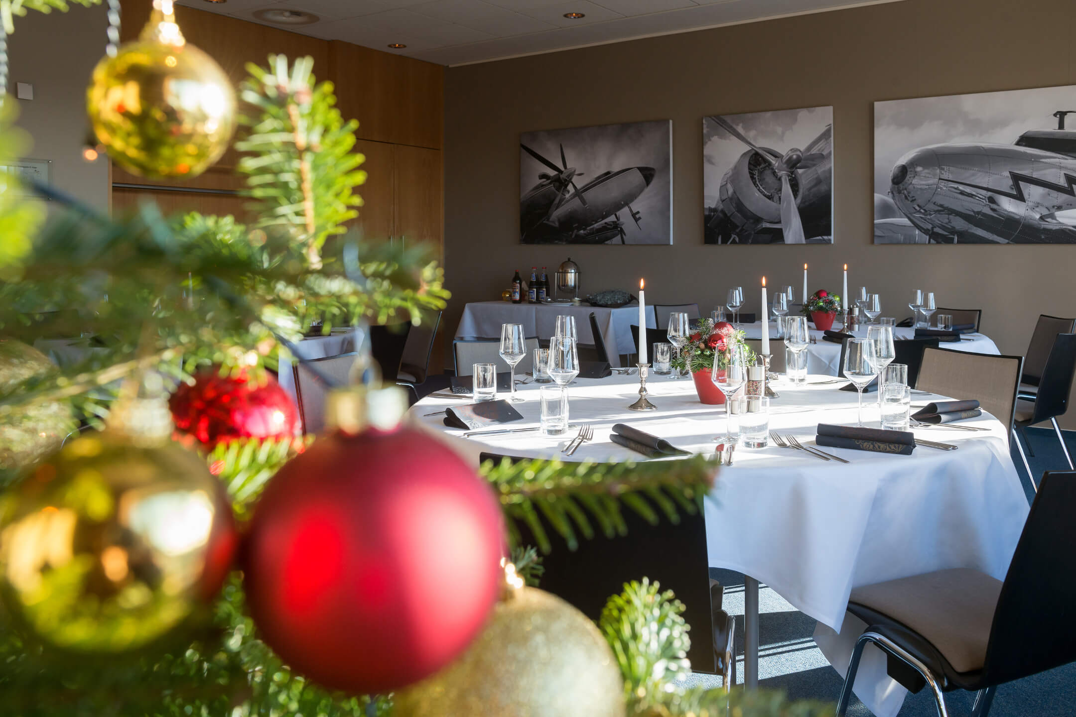 Christmas tree and decorated tables in function room Trans-Atlantik in ATLANTIC Hotel Airport Bremen
