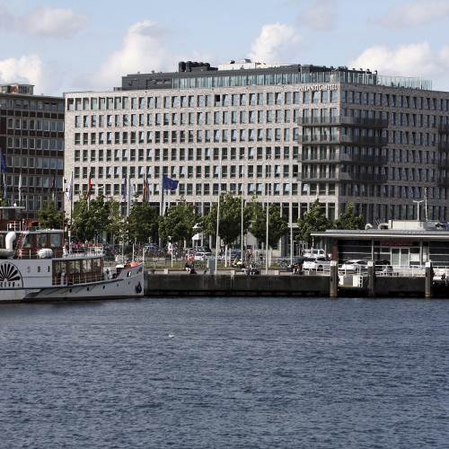 Platzhalter Kontaktbild ATLANTIC Hotel Kiel, modernes Gebäude am Wasser mit Hafenblick, im Vordergrund ein Schiff am Kai.