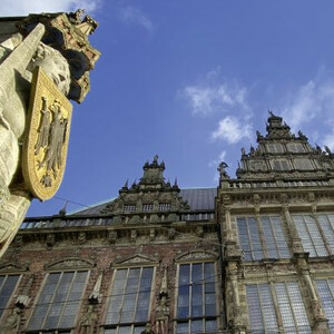 Roland und Rathaus Bremen Historisches Gebäude in Bremen mit verziertem Steinrelief und blauem Himmel im Hintergrund.