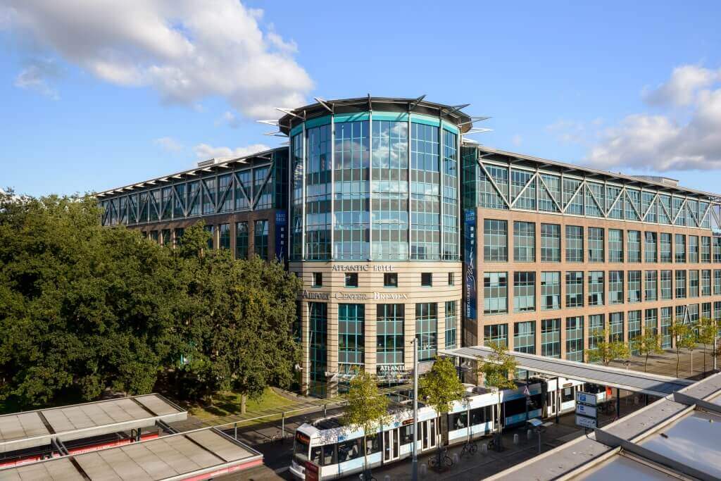 ATLANTIC Hotel Airport – exterior view with tram in front of the hotel