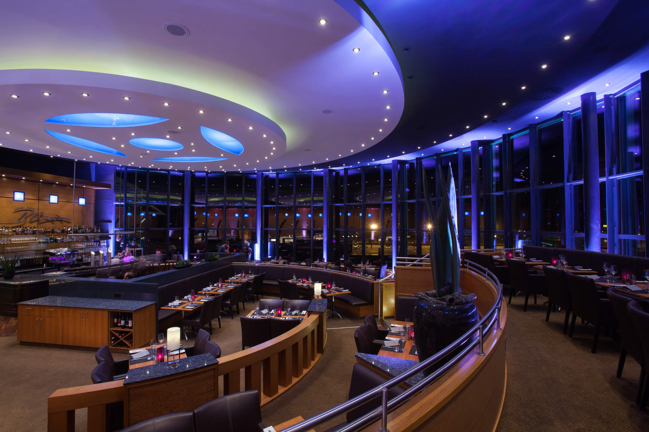 Modernes Restaurant mit eleganter Beleuchtung und Panoramafenstern im ATLANTIC Hotel Airport Bremen.