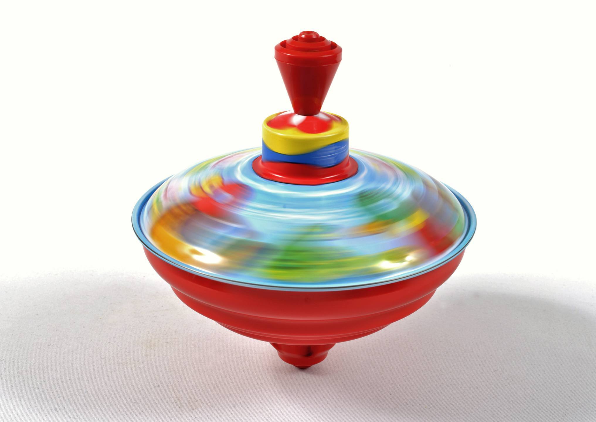 Kreisel im ATLANTIC Hotel Airport in Bremen Ein bunter Kreisel dreht sich schnell auf einer weißen Oberfläche.