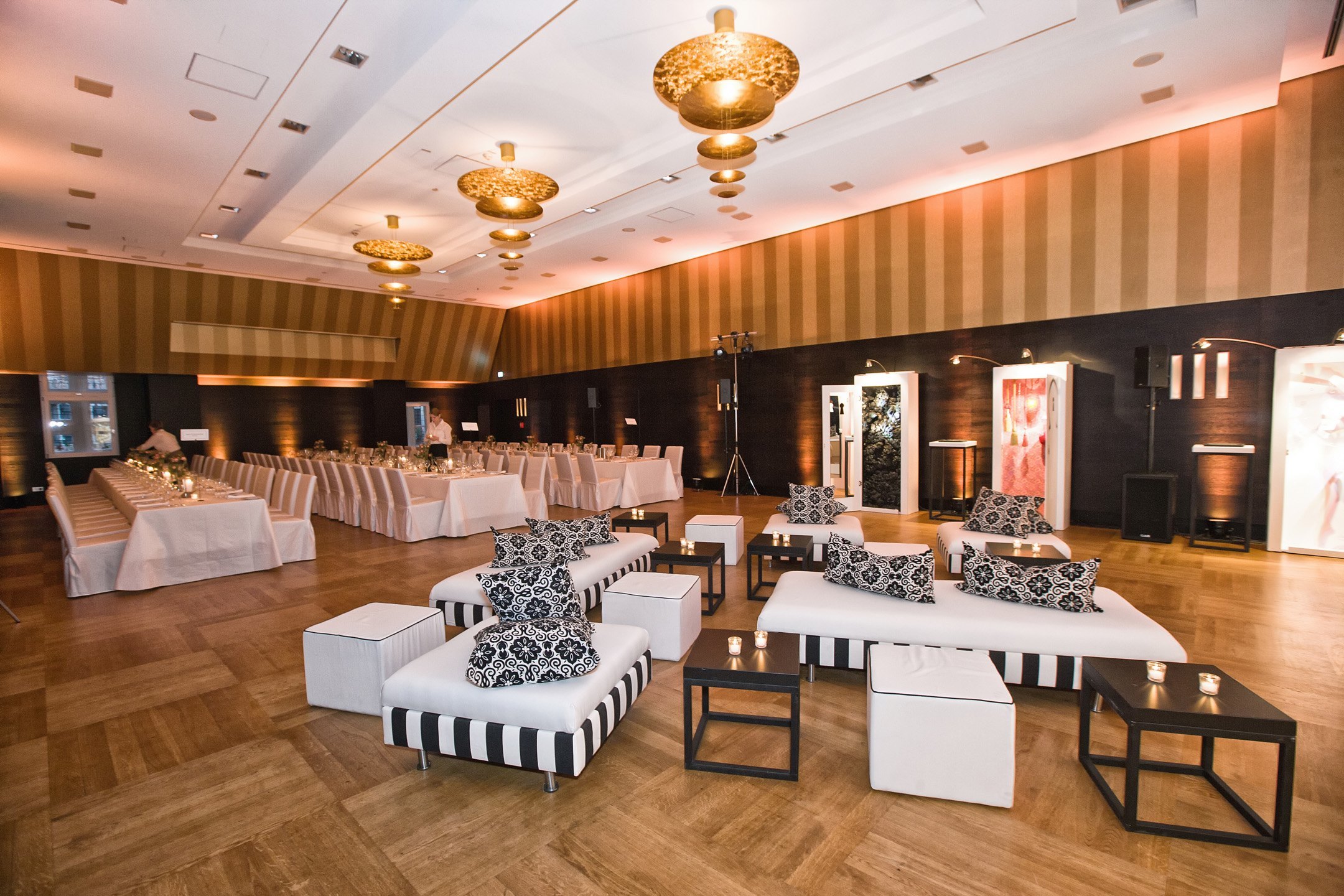 Modern banquet hall in the ATLANTIC Grand Hotel Bremen with elegant lighting, laid tables and stylish seating areas.