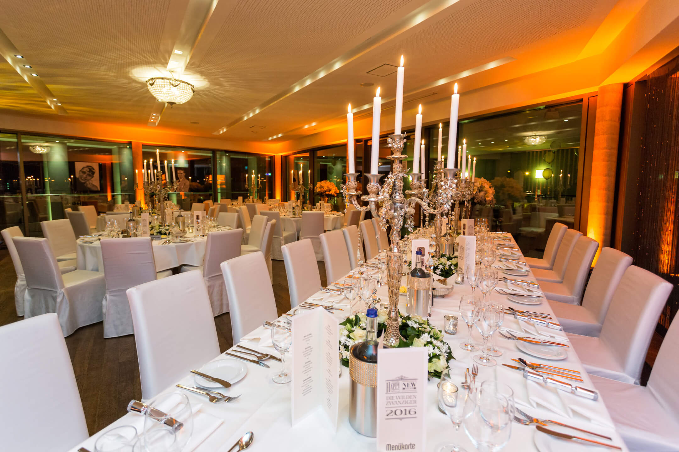 Elegant ballroom in the ATLANTIC Grand Hotel Bremen, with tables laid in white, candlesticks and stylish lighting.