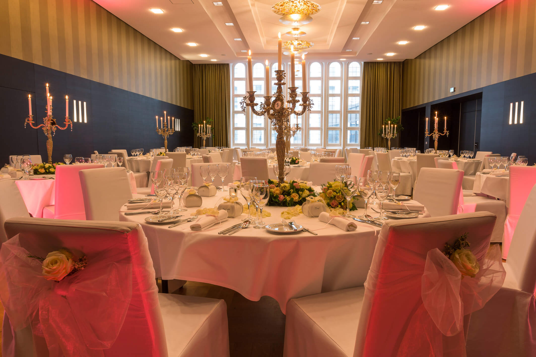 Elegant banquet hall in the ATLANTIC Grand Hotel Bremen, festively laid tables with candlesticks and flower arrangements.