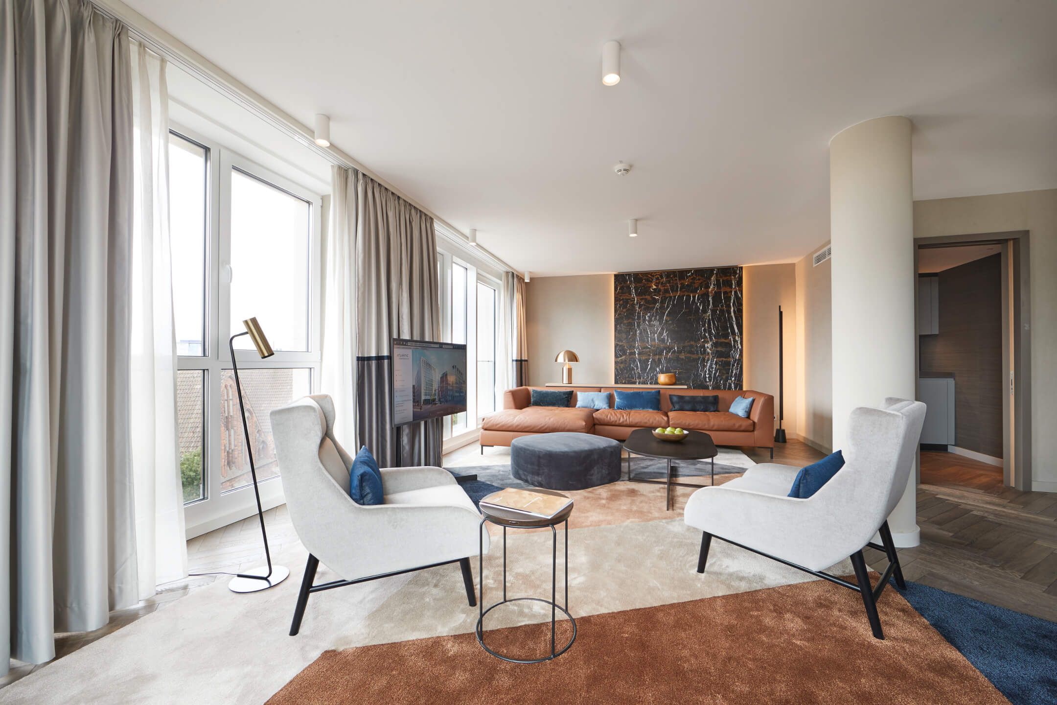 Wohnzimmer Grand Suite im Atlantic Grand Hotel Bremen Elegantes Hotelzimmer mit großen Fenstern, modernen Möbeln und stilvollem Dekor im ATLANTIC Grand Hotel Bremen.