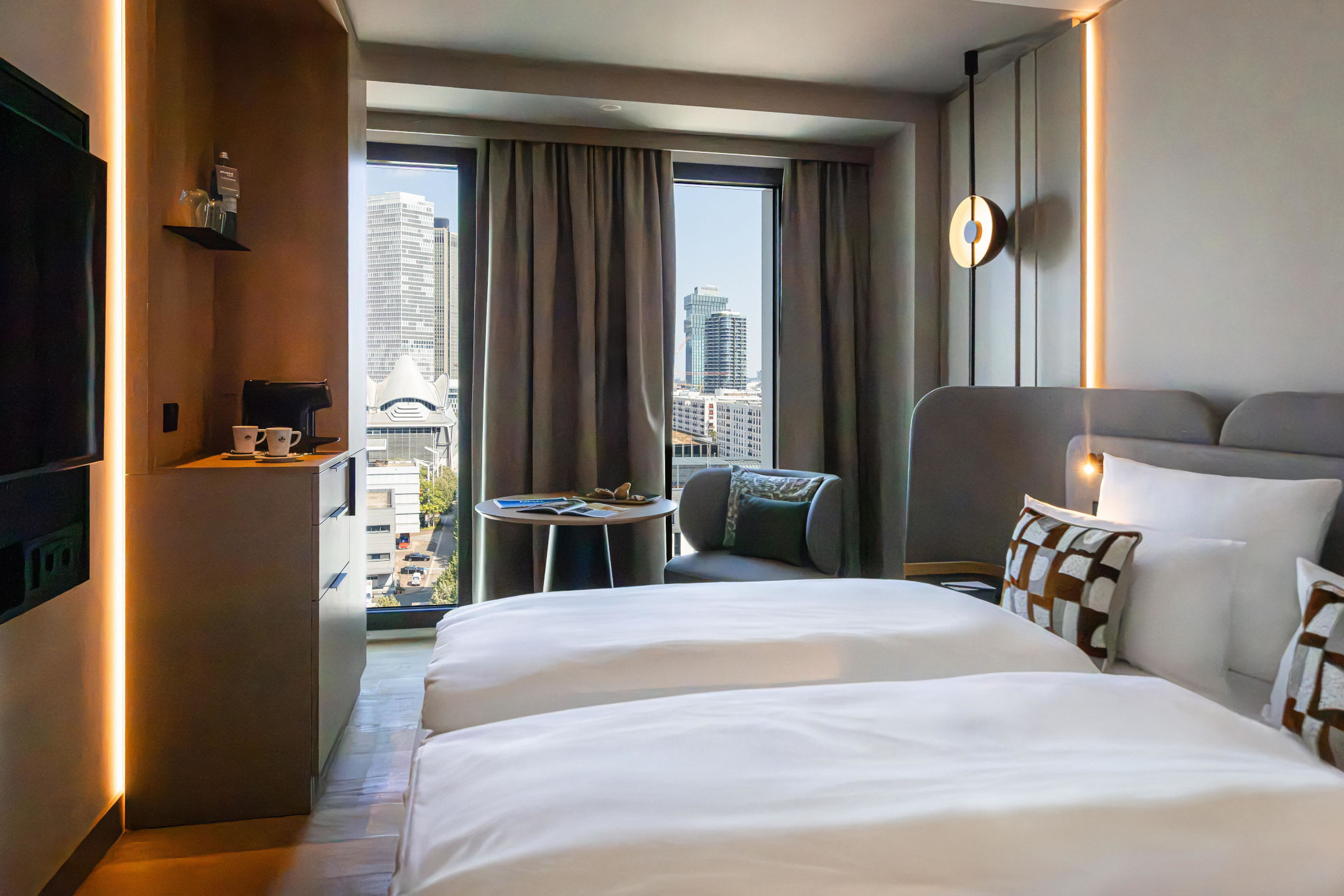 Ausblick auf die Frankfurter Skyline vom Bett im Skyline Zimmer. 