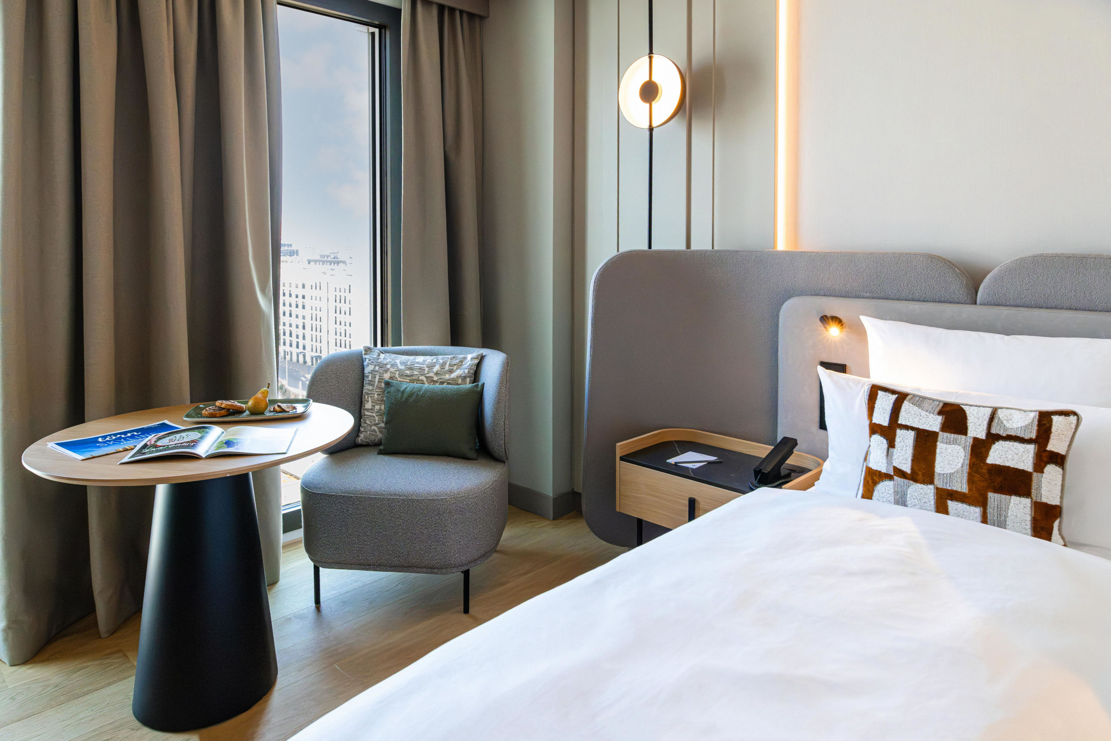 Sessel mit Beistelltisch und Bett im Skyline Zimmer.