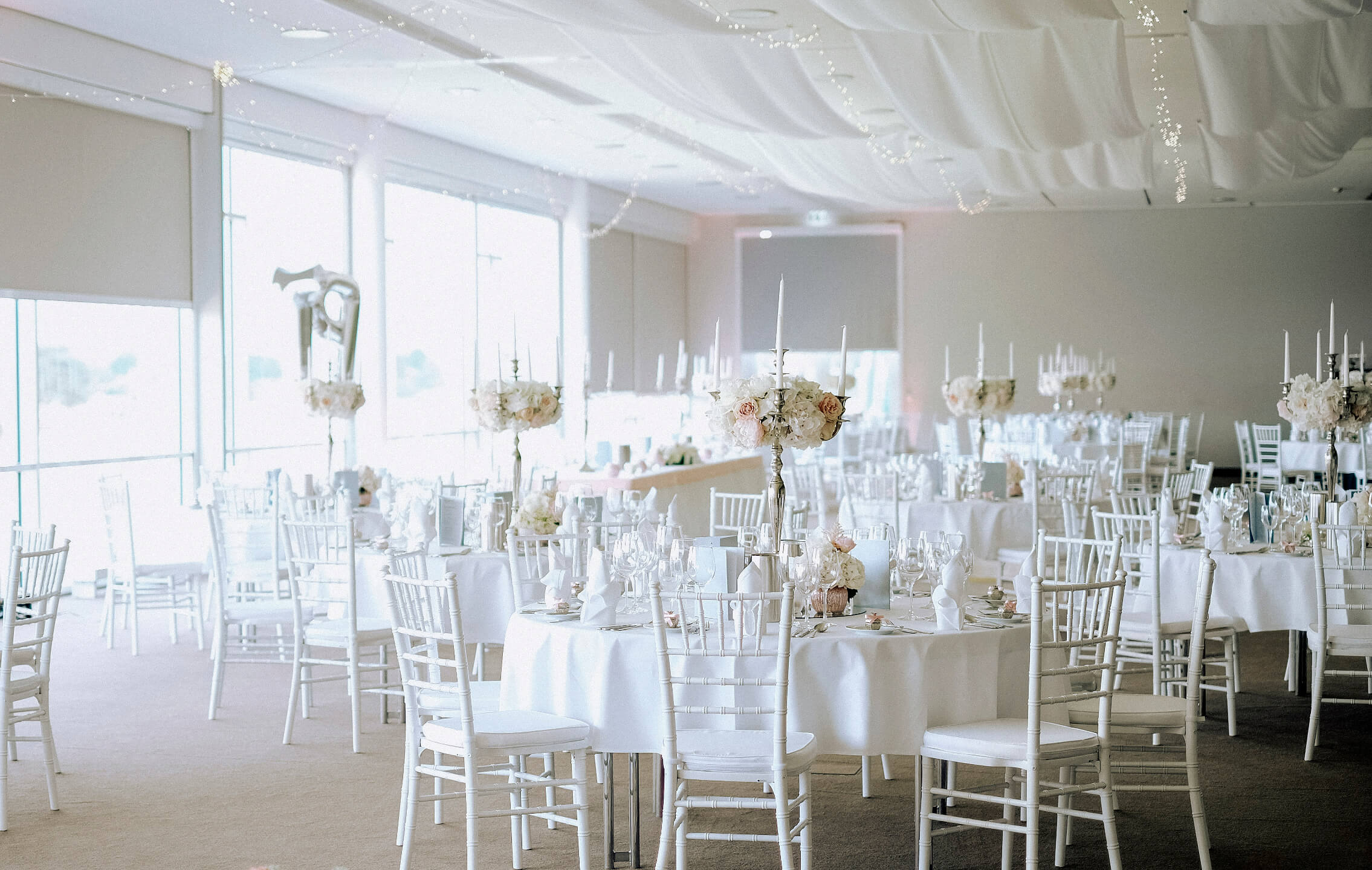 Veranstaltungsraum mit festliche eingedeckten Tischen für eine Hochzeitsfeier