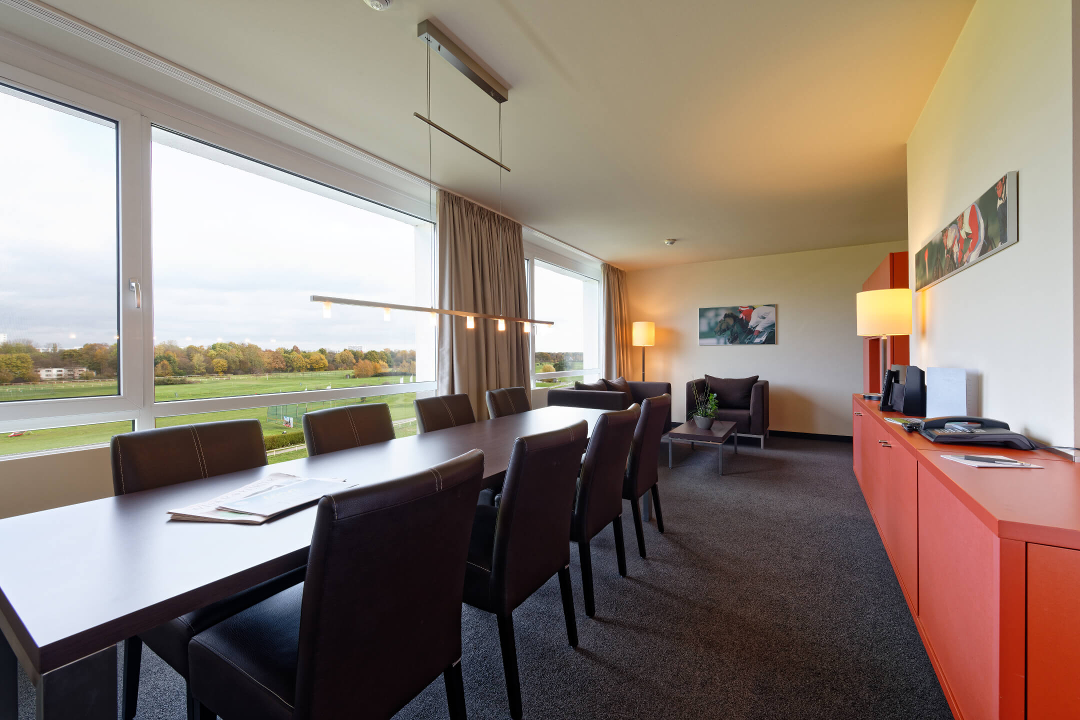 Bright conference room in the ATLANTIC Hotel with a large table, leather armchairs and a view of the racecourse.