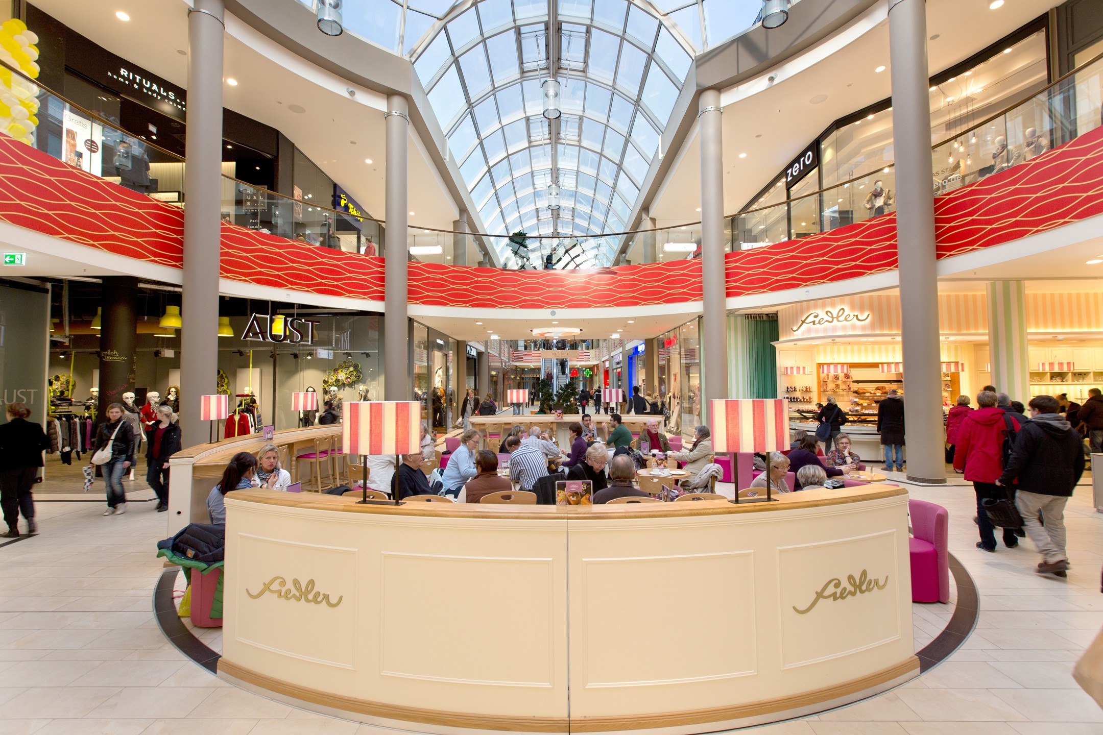 Shopping centre Sophienhof interior view Shopping center with glass roof, stores and café area, people shopping and relaxing.