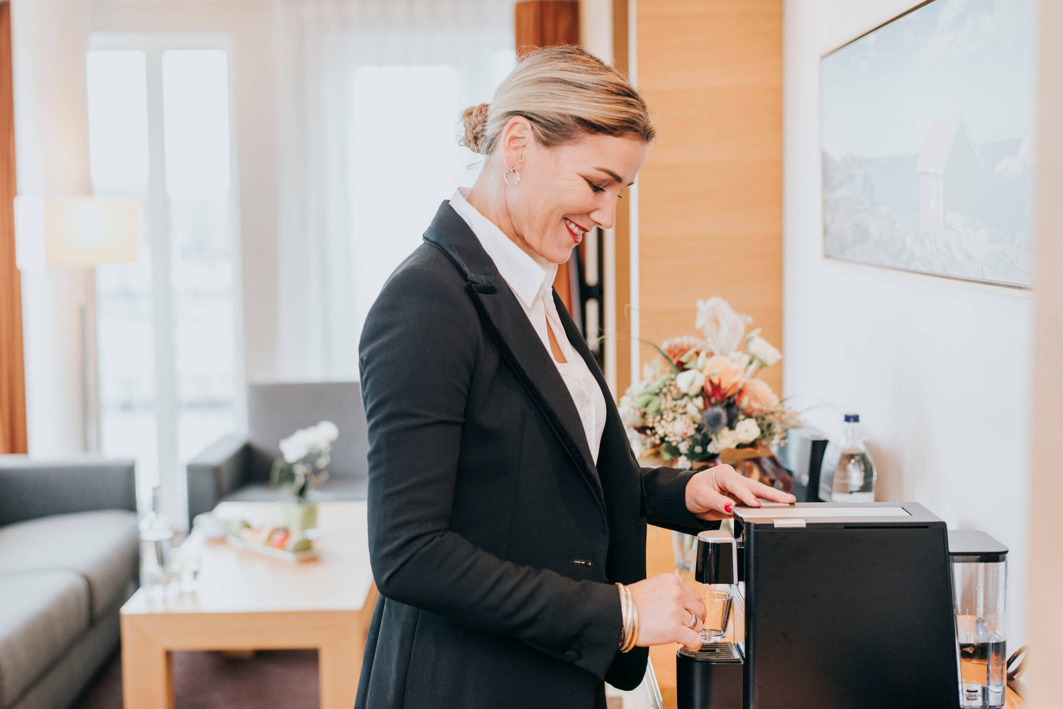 Wohnbereich mit Sofas, Kaffeemaschine und Blumen in der Suite im ATLANTIC Hotel Kiel