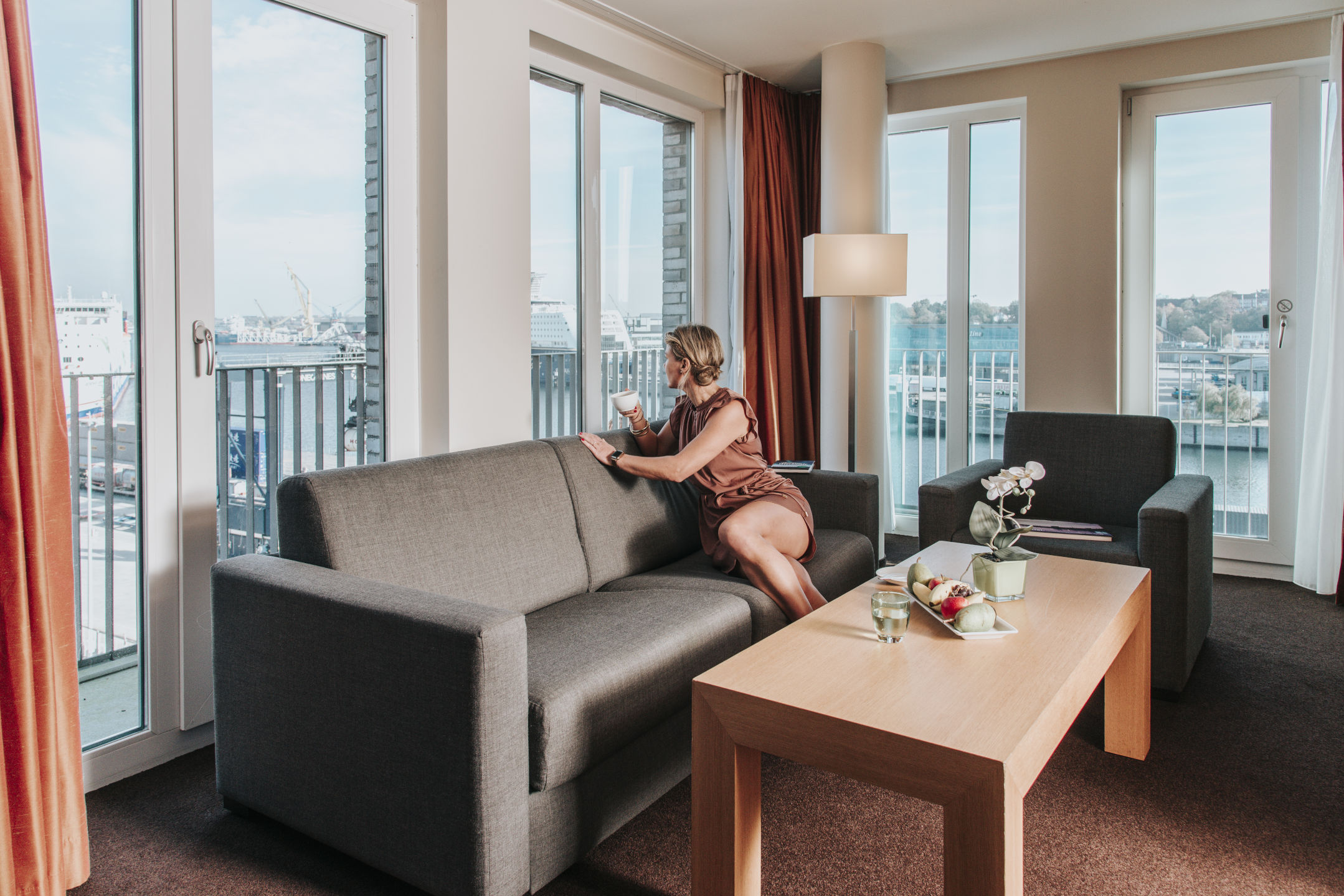 Wohnbereich mit Sofa, Tisch und Blumen in der Suite im ATLANTIC Hotel Kiel