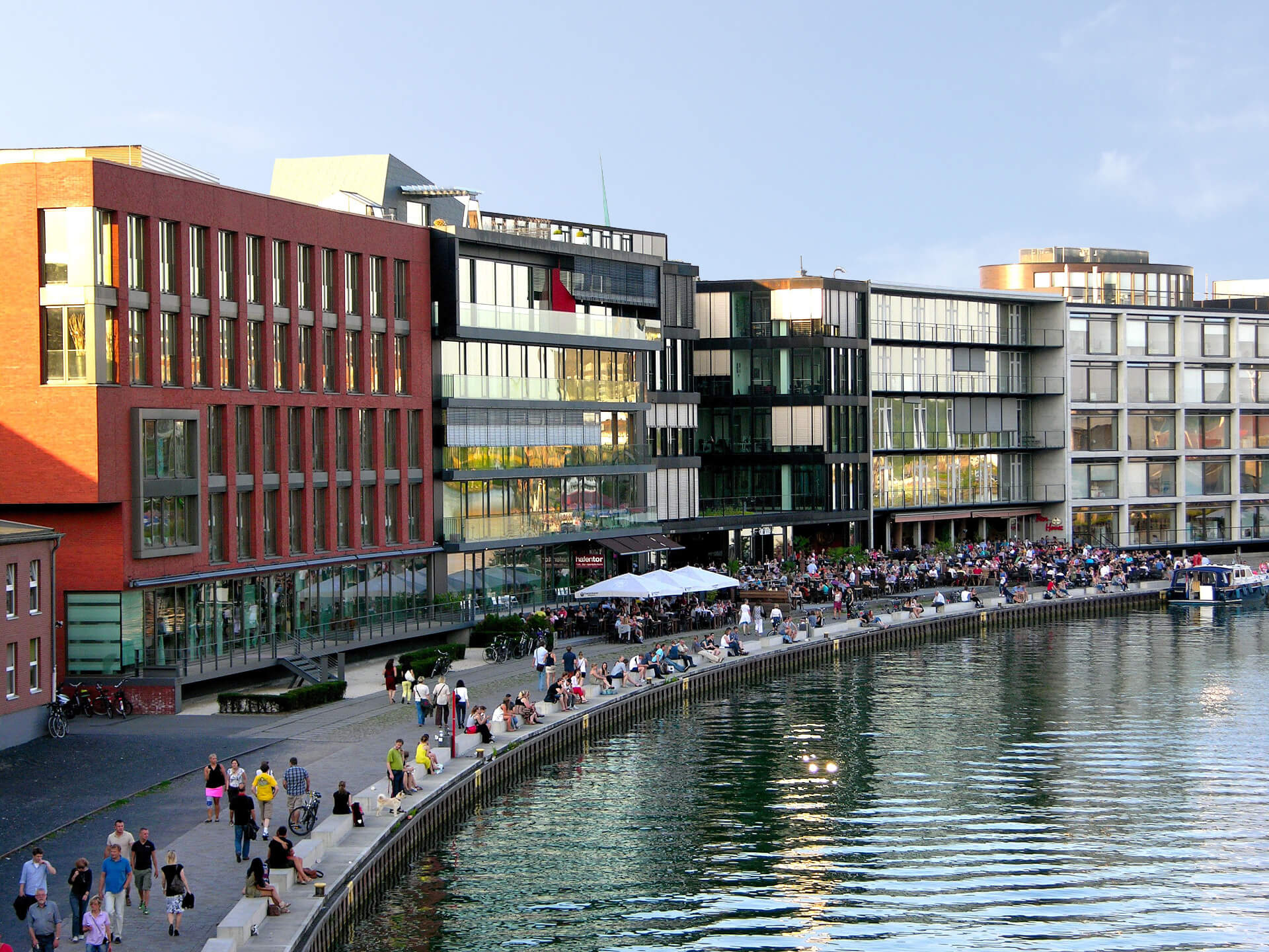 Münster Stadthafen Modern buildings on the waterfront with lots of people on the promenade, sunny day.