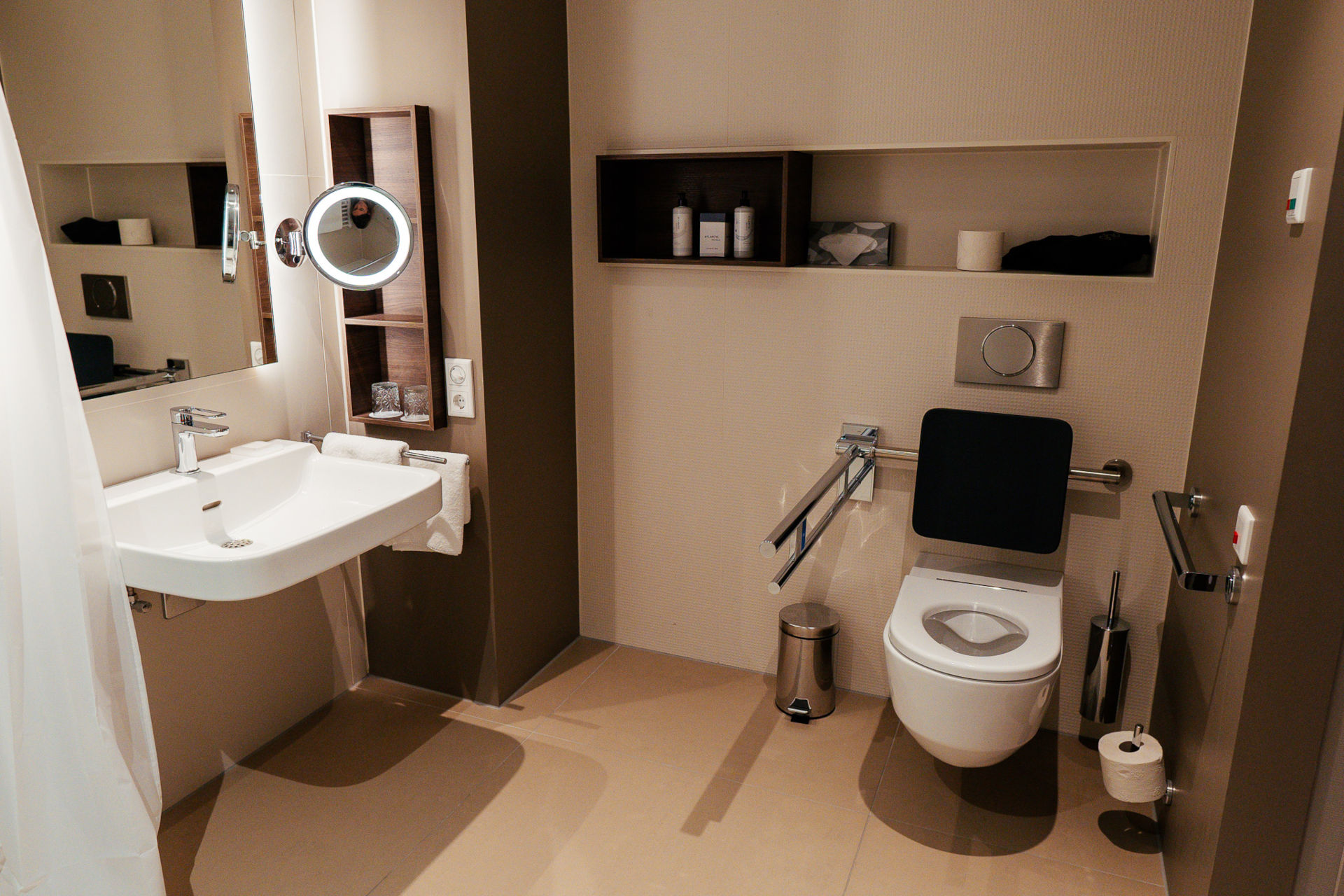 Ansicht des Badezimmers mit WC mit Haltegriffen und Notrufknopf im barrierefreien Zimmer
