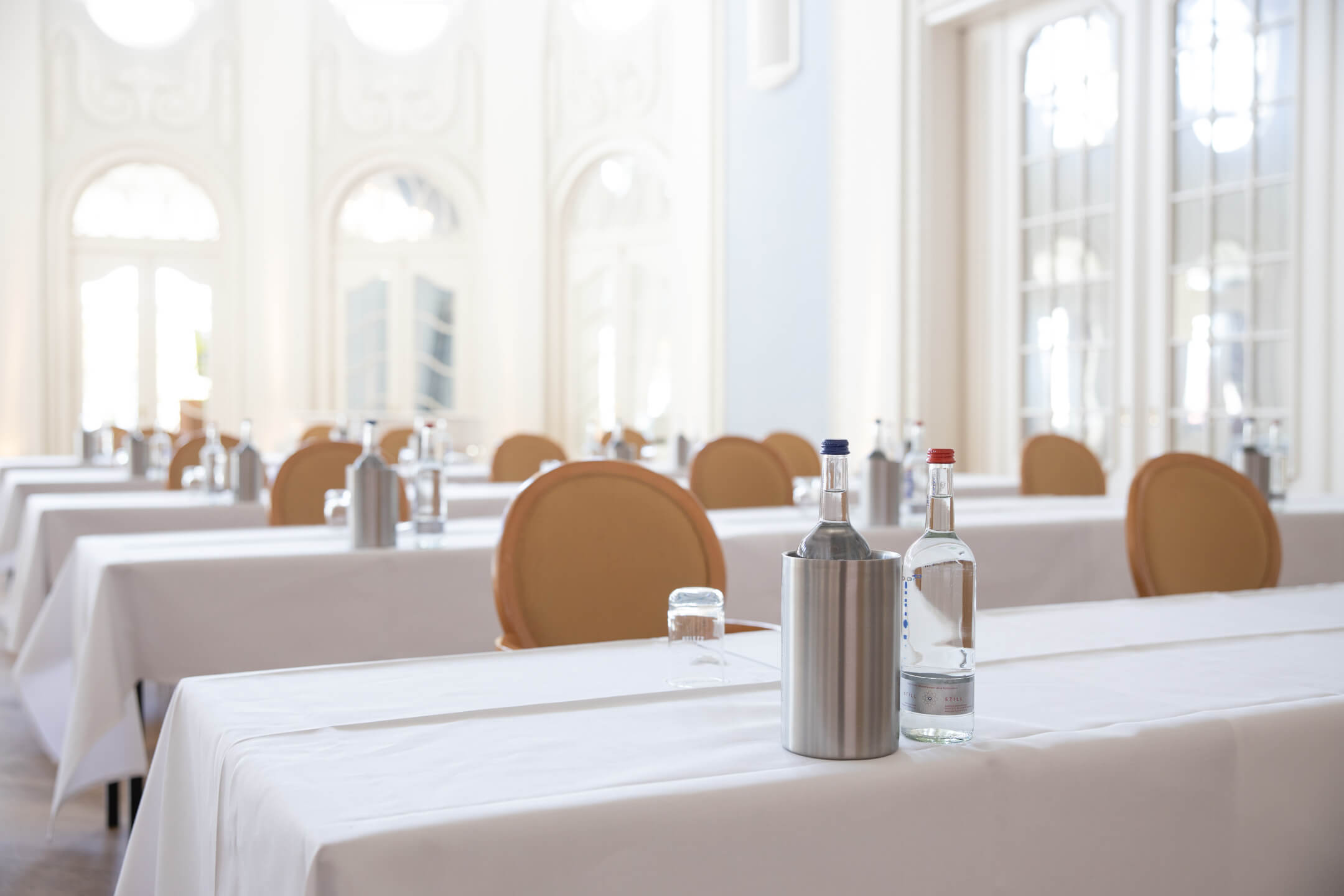 Veranstaltungen Ballsaal 3 | ATLANTIC Grand Hotel Travemünde Heller, eleganter Konferenzraum mit gedeckten Tischen, Wasserflaschen und stilvollen Stühlen im ATLANTIC Grand Hotel Travemünde.