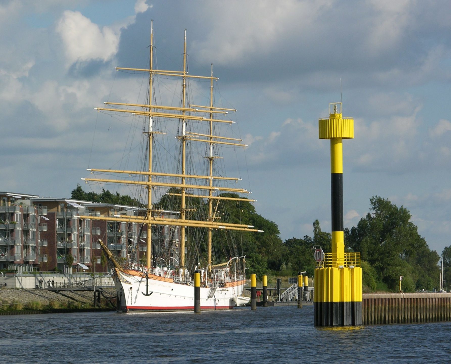 Segelschiff am Ufer mit gelber Boje im Vordergrund, nahe ATLANTIC Hotel Vegesack, Bremen.