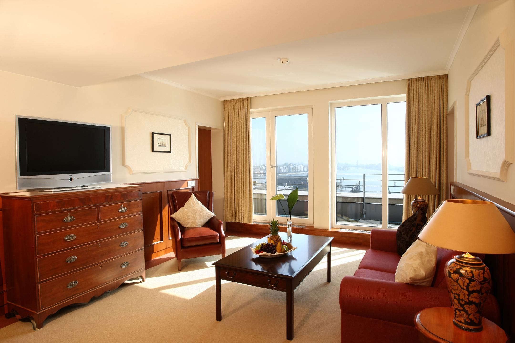 Wohnzimmer der Gorch Fock Suite mit Sofa und Flatscreen TV im ATLANTIC Hotel Wilhelmshaven