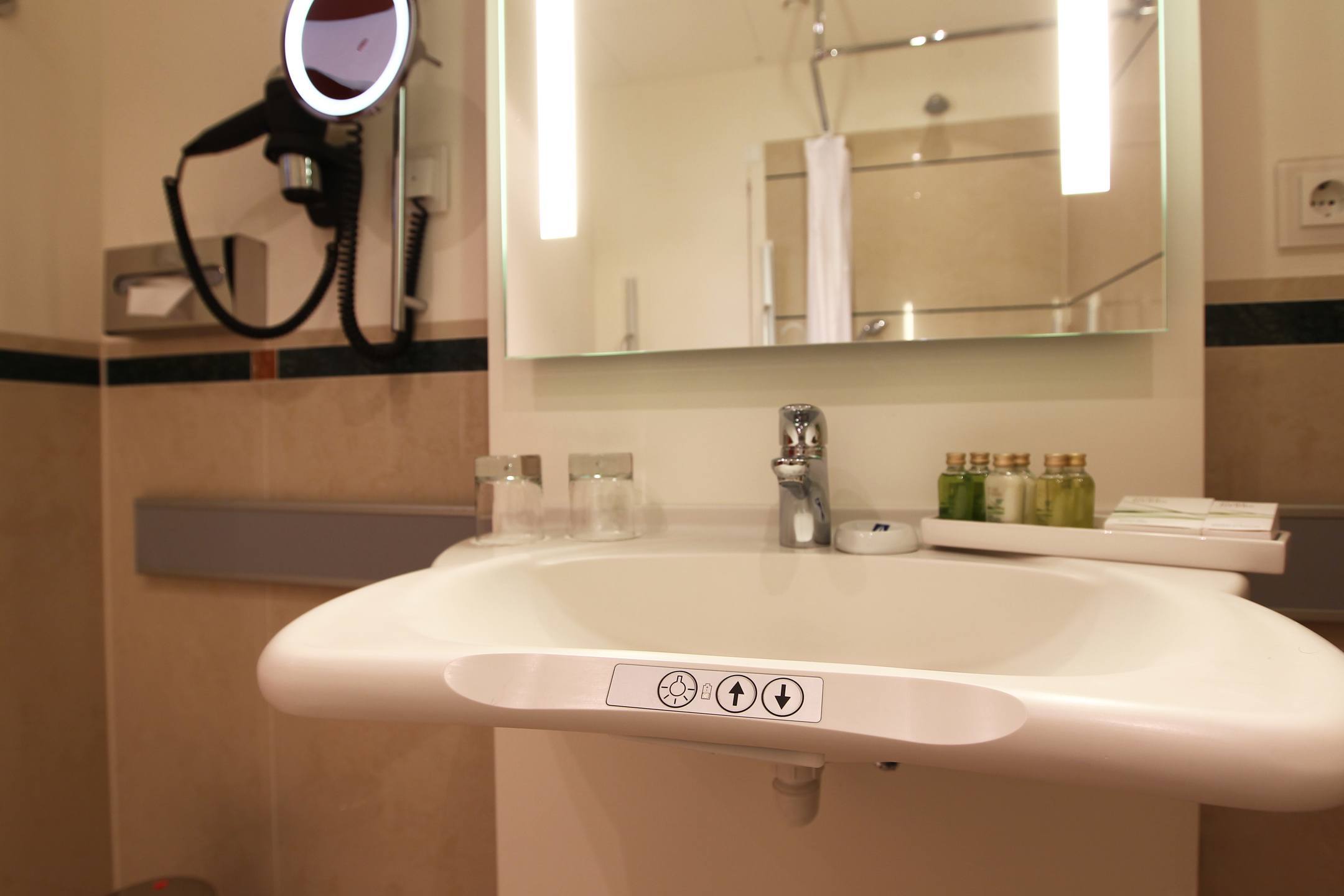 Waschbecken mit Bedienelementen für berrierefreien Zugang des Standard Zimmer barrierefrei im ATLANTIC Hotel Wilhelmshaven