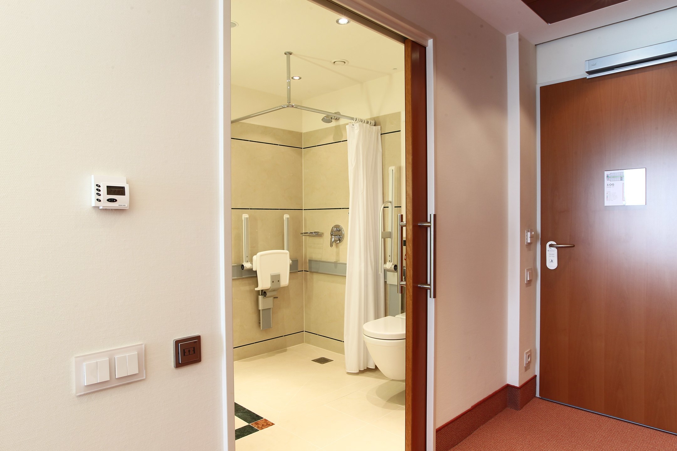 Blick durch die Tür zum Badezimmer des Standard Zimmer barrierefrei des ATLANTIC Hotel Wilhelmshaven