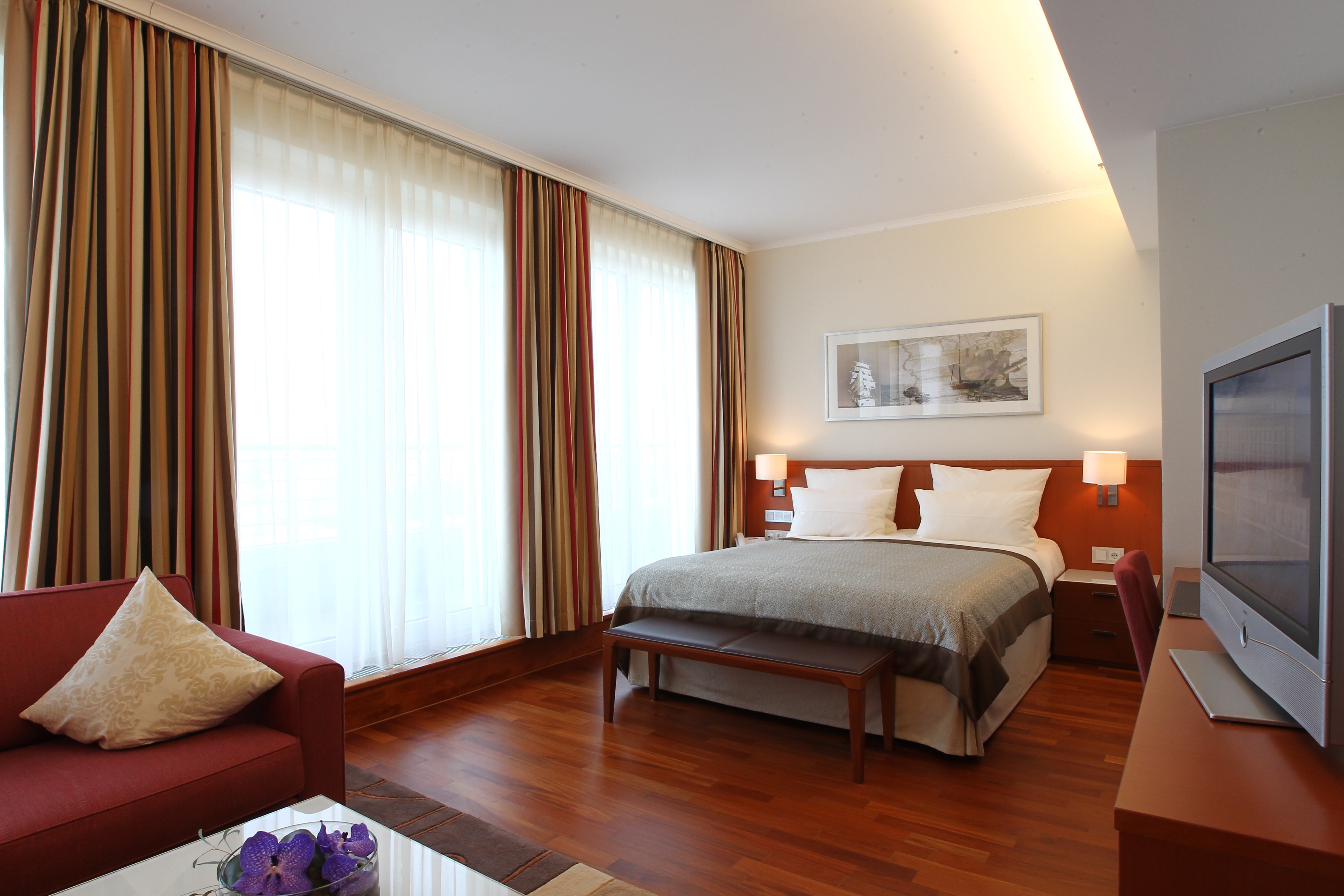 Schlafzimmer mit großem Bett im Executive Zimmer des ATLANTIC Hotel Wilhelmshaven