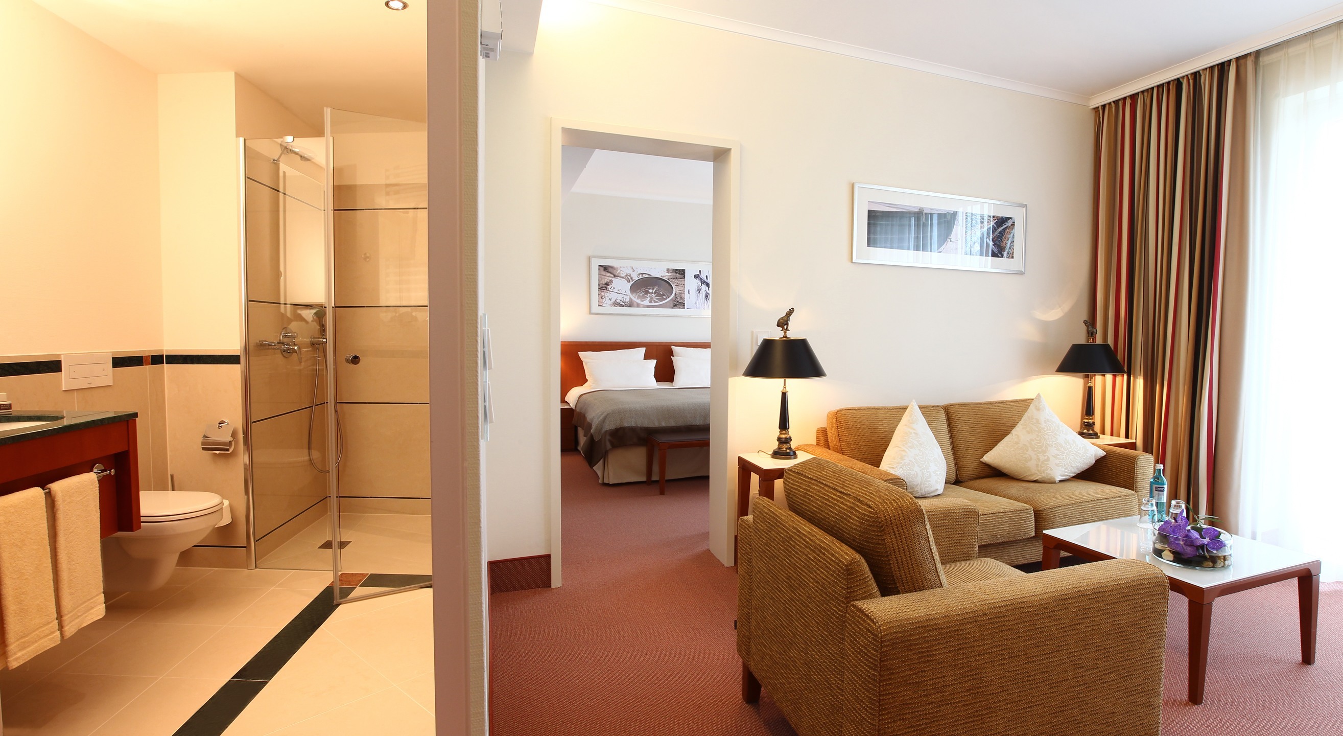 Blick in das Schlafzimmer und Badezimmer des Comfort Suite im ATLANTIC Hotel Wilhelmshaven