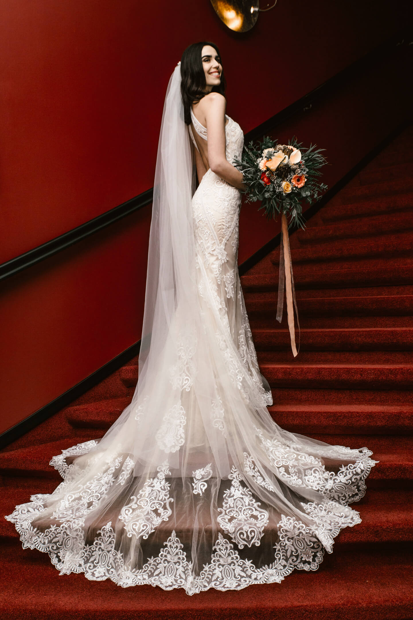 Porträtfoto Braut im eleganten weißen Kleid auf der roten Treppe im ATLANTIC Grand Hotel Bremen