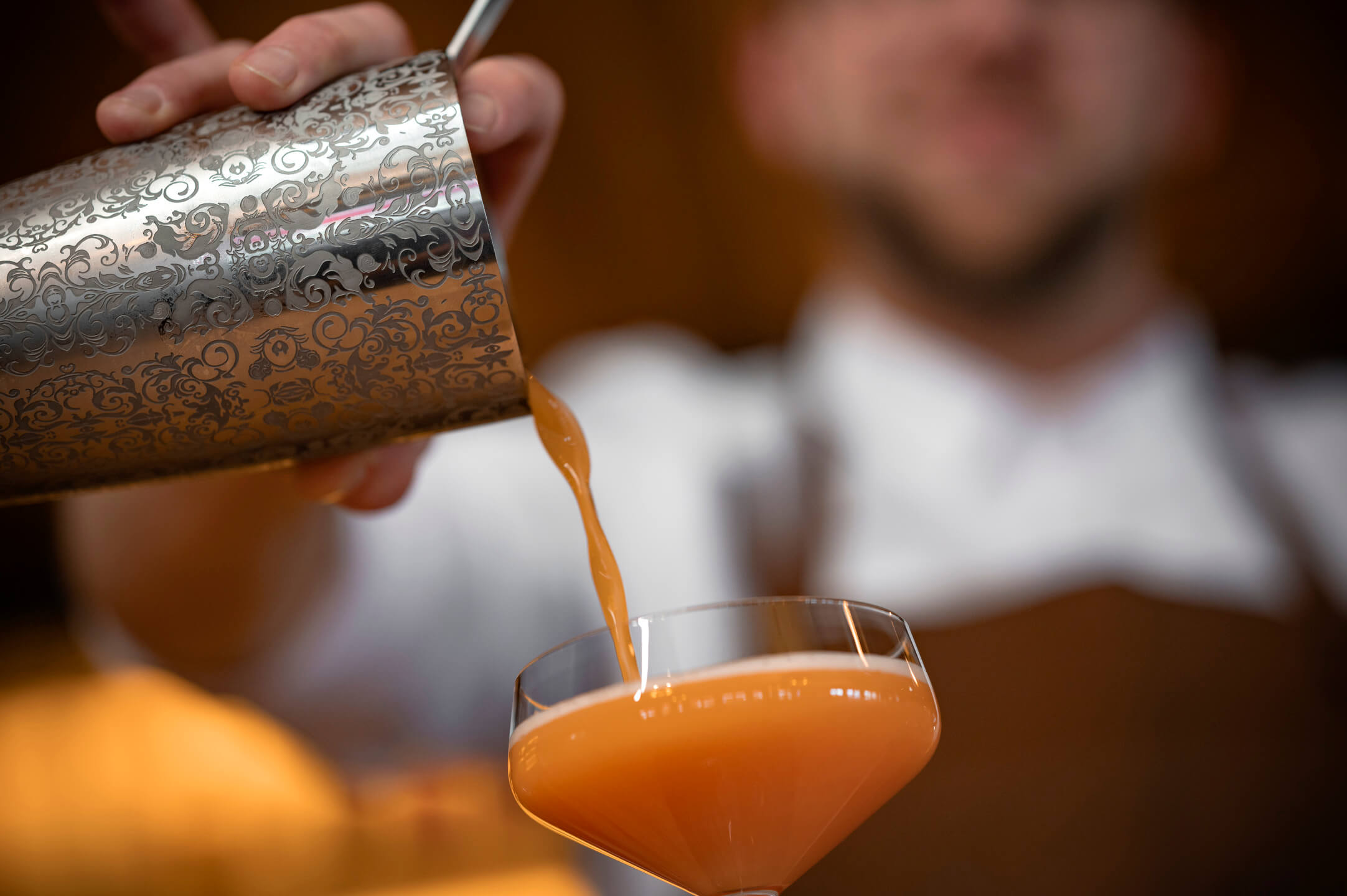Bartender pours a drink in the CHALET restaurant at the ATLANTIC Hotel Landgut Horn