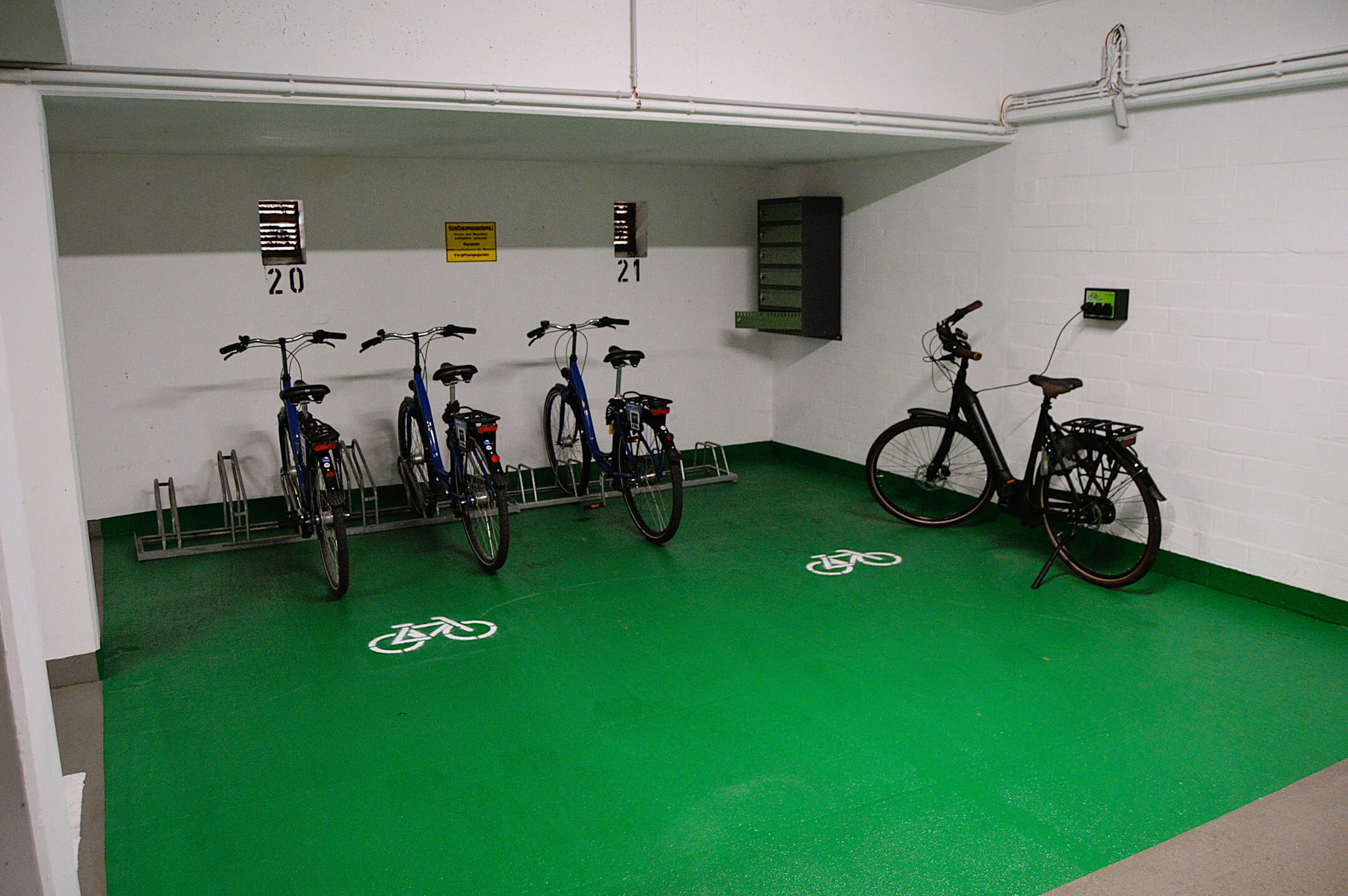 Fahrradstellplätze mit Ladestationen in einem grünen Bereich des ATLANTIC Hotel Landgut Horn Bremen.