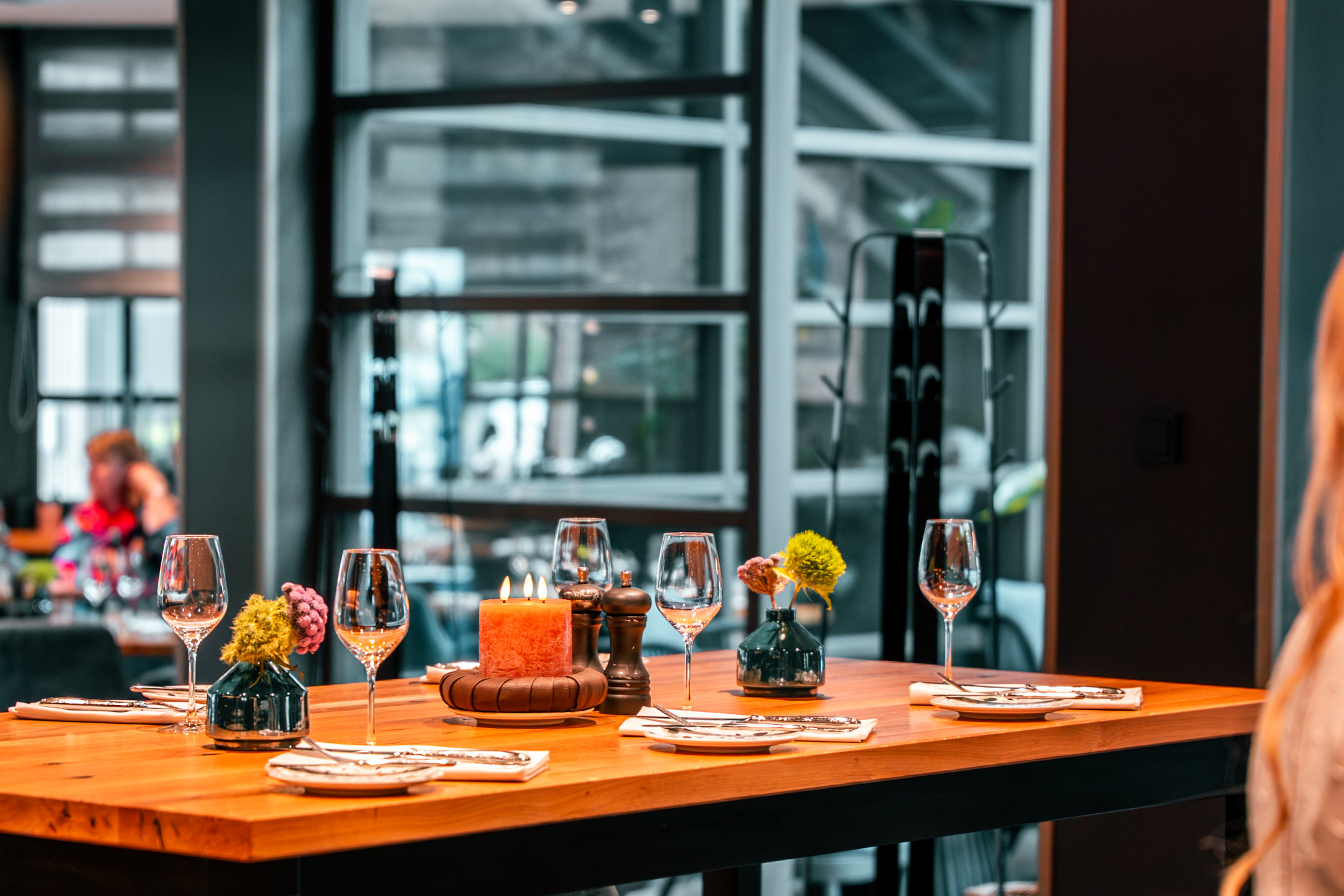 a standing table with vases, candles and wine glasses at Chalet.