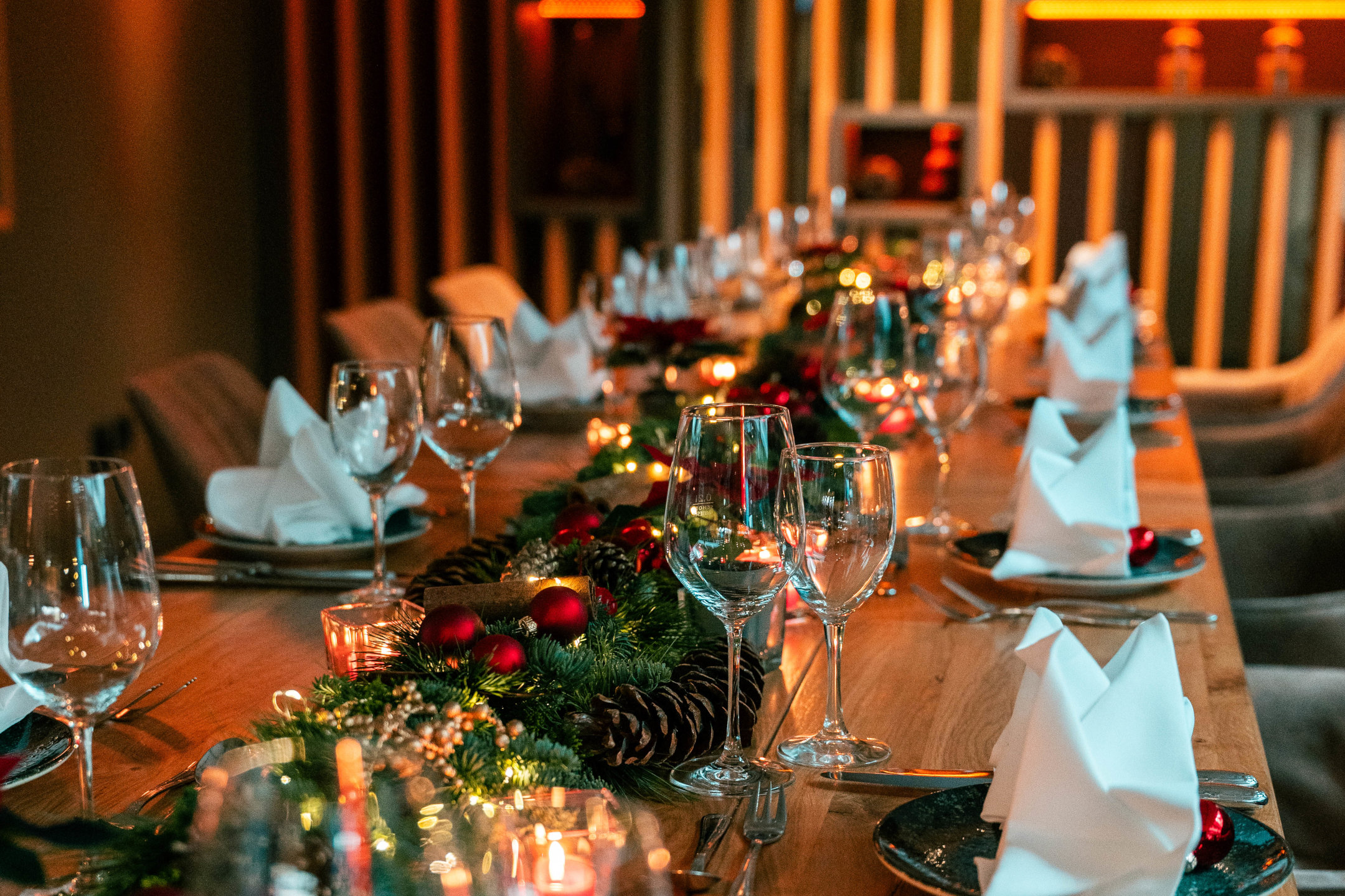 Weihnachtlich gedeckte Tafel mit Tannengrün und Lichterkette