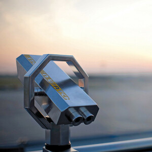 Telescope on a viewing platform at sunset with a view of the horizon.