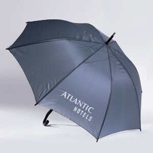 Regenschirm Dunkelblauer Regenschirm mit der Aufschrift "Atlantic Hotels", geöffnet auf hellem Hintergrund.