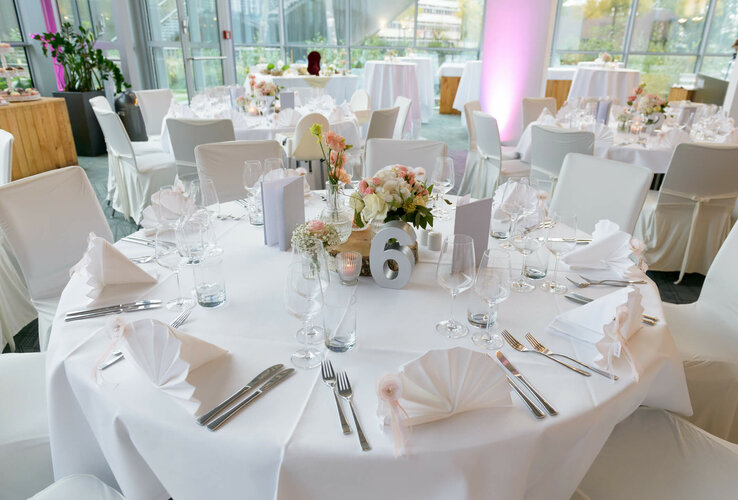 Elegante, festlich gedeckte Tische im ATLANTIC Hotel Universum mit Blumenarrangements und weißer Tischwäsche.