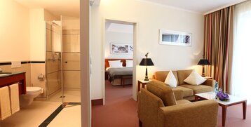 Blick in das Schlafzimmer und Badezimmer der Comfort Suite im ATLANTIC Hotel Wilhelmshaven