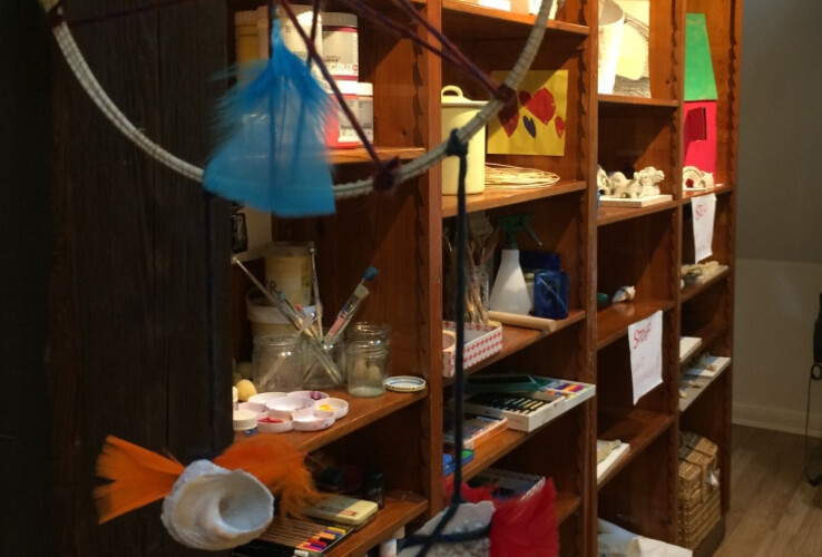 Regale mit Bastelmaterialien und Kunstwerken im ATLANTIC Hotel Airport Bremen.