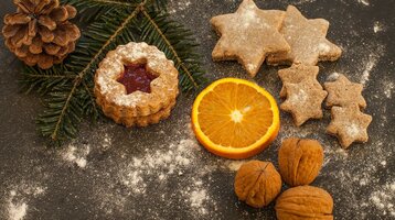 Celebrate Christmas at the ATLANTIC Hotels Christmas cookies, orange slice, walnuts and fir branch on a floured base.