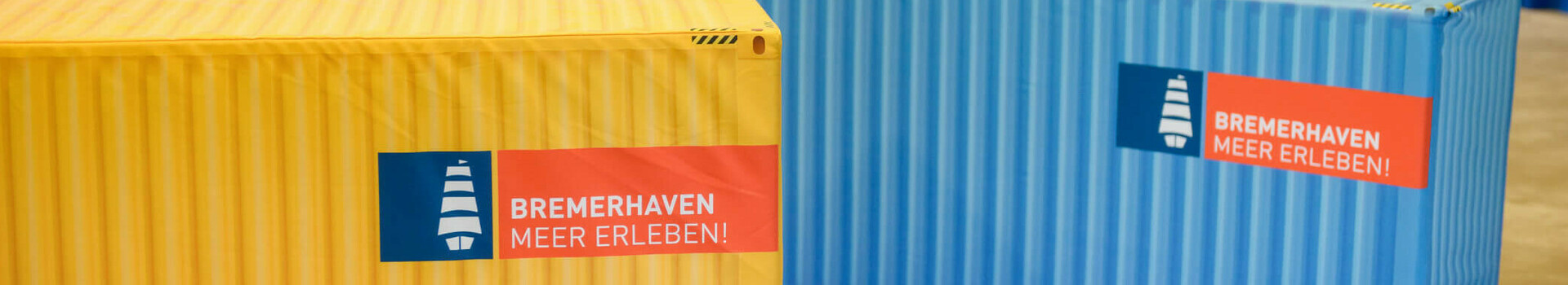Team Camp im ATLANTIC Hotel Sail City  Bunte Sitzsäcke und Container im ATLANTIC Hotel Sail City, Bremerhaven, mit "Bremerhaven Meer Erleben!"-Logo.