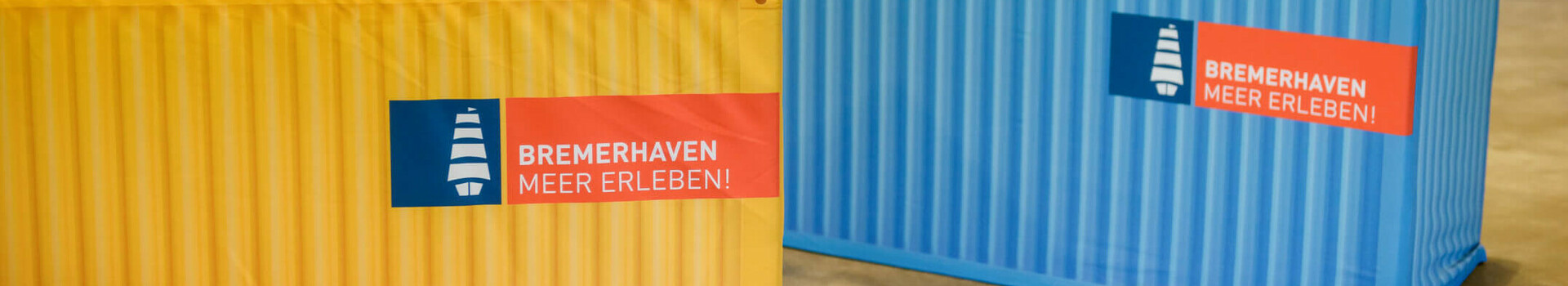 Bunte Sitzsäcke und Container im ATLANTIC Hotel Sail City, Bremerhaven, mit "Bremerhaven Meer Erleben!"-Logo.