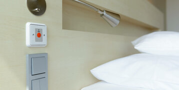 Reading lamp and emergency call button next to a bed in the ATLANTIC Hotel Sail City, Bremerhaven.