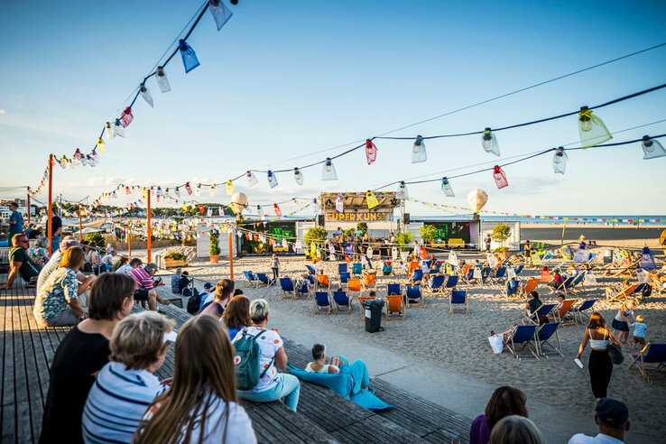 Personen an sitzen an der festlich geschmückten Promenade am Travemünder Strand