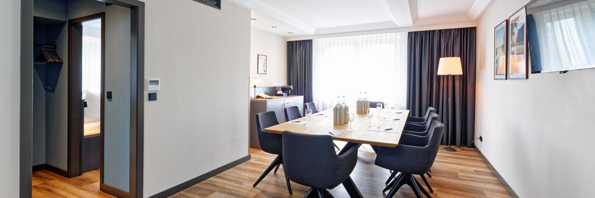 Moderner Konferenzraum im ATLANTIC Hotel Landgut Horn mit großem Tisch, Stühlen und Tageslicht.