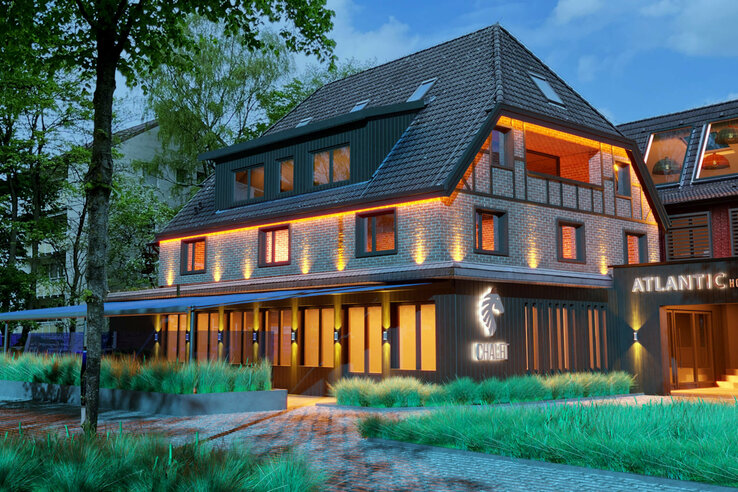 Beleuchtetes Hotelgebäude des ATLANTIC Hotel Landgut Horn Bremen mit Garten und Eingang bei Abenddämmerung.