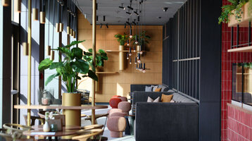 Deli Lounge at the ATLANTIC Hotel Heidelberg Modern hotel lounge area with stylish sofas, plants and hanging lamps at the ATLANTIC Hotel Heidelberg.