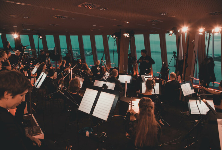 EDM meets Classic in Bremerhaven Orchester spielt im ATLANTIC Hotel Sail City mit Blick auf die Fenster und den Hafen von Bremerhaven.