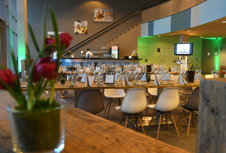 Elegantes Restaurant im ATLANTIC Hotel Sail City mit gedeckten Tischen, moderner Dekoration und Bar im Hintergrund.