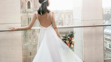 Roof terrace of the ATLANTIC Grand Hotel Bremen - View direction St. Petri church  Bride in white dress looks from the balcony of the ATLANTIC Grand Hotel Bremen at the city and the church, holding a bouquet of flowers.