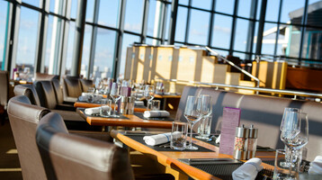 Elegantes Restaurant im ATLANTIC Hotel Airport Bremen, mit gedeckten Tischen und großer Fensterfront.