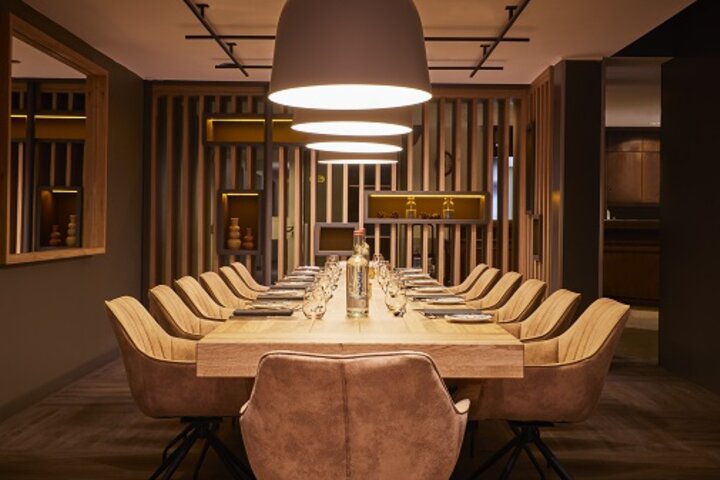 Restaurant CHALET im ATLANTIC Hotel Landgut Horn Eleganter Konferenzraum im ATLANTIC Hotel Landgut Horn mit großem Holztisch, stilvollen Stühlen und warmem Licht.