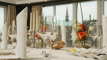 Set table in the Roof Lounge of the ATLANTIC Hotel Lübeck – Lübeck skyline in the background Set table in the Roof Lounge of the ATLANTIC Hotel Lübeck – Lübeck skyline in the background